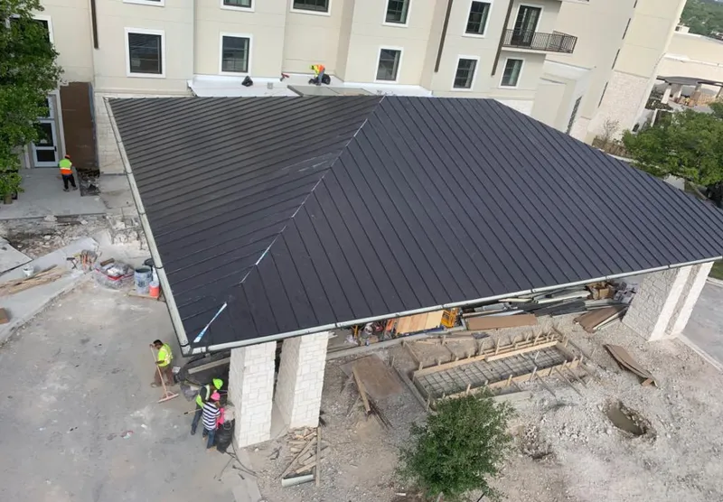 Metal roofing installation team working on a commercial building in Fall River
